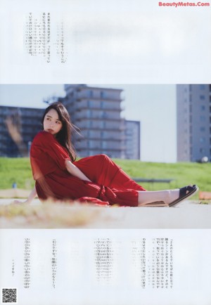 A woman sitting on the floor with her hand on her chin.