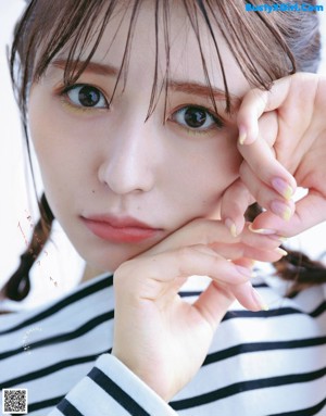 A woman with long brown hair is posing for a magazine.