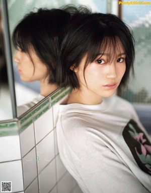 A woman sitting on top of a locker reading a book.