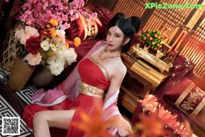 A woman in a red dress sitting on a red couch.