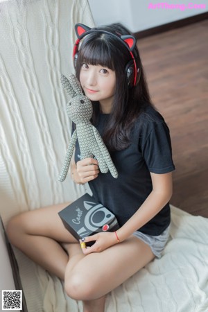 A woman sitting on a chair with headphones on.