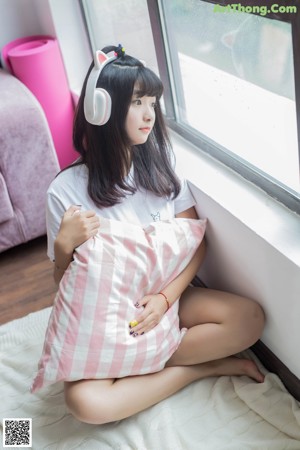 A woman in a white shirt holding a box of cat ears.