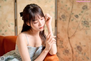 A woman in a blue dress holding a piece of cake.