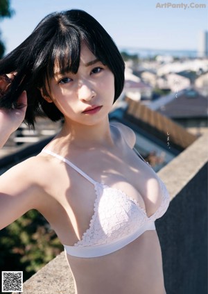 A woman in a brown sweater and black stockings sitting on a window sill.