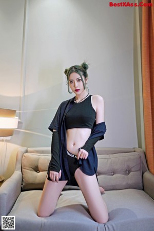 A woman sitting on a chair in front of a mirror.