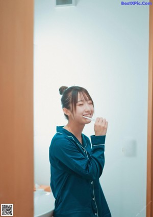 A woman holding a pink envelope in front of her face.