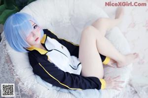 A woman with blue hair wearing a black and white jacket.