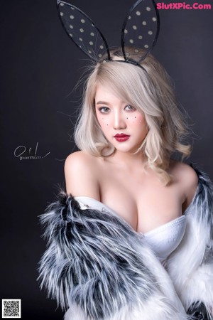 A woman in a white dress and black and white fur coat.