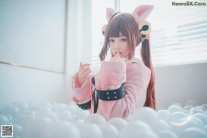 A woman in a bunny costume is posing in a ball pit.