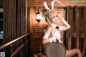 A woman in bunny ears sitting on a blue couch.