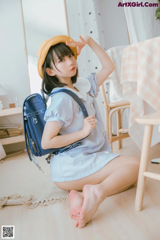 a woman sitting on the floor with a backpack