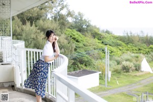 A woman in a white shirt is posing for the camera.