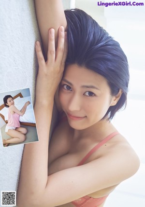 A woman in a black bathing suit sitting on the floor.