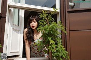 A naked asian woman posing in front of a window.