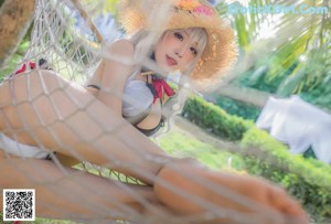 A woman in a bikini and a straw hat posing for a picture.