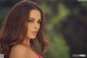 A woman in a red top posing for a picture.