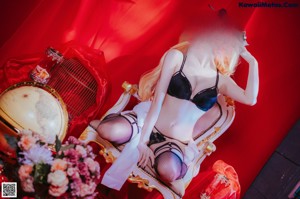 A woman in lingerie sitting on a chair.